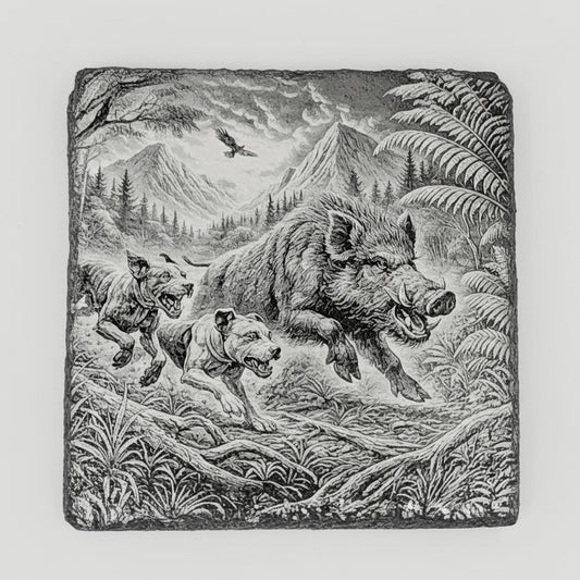 The Take Down: Two-Dog Edition slate coaster engraved with a boar and two dogs in a mountain landscape with ferns and a bird overhead