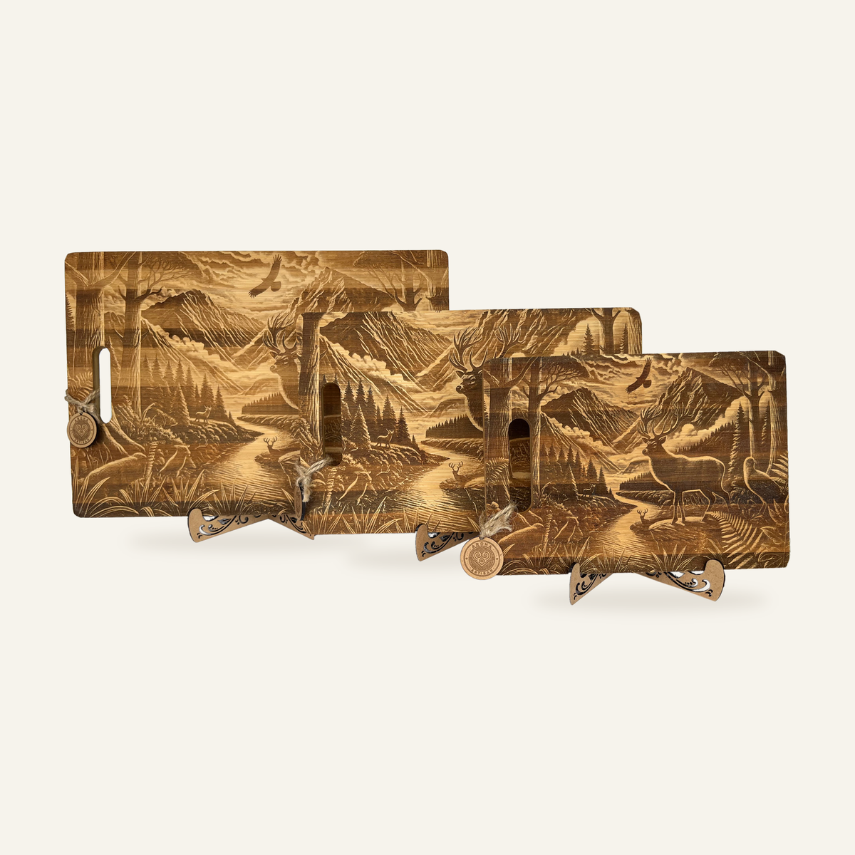 Three Hunter’s Sunrise engraved wooden boards displayed together on decorative stands against an ivory background.