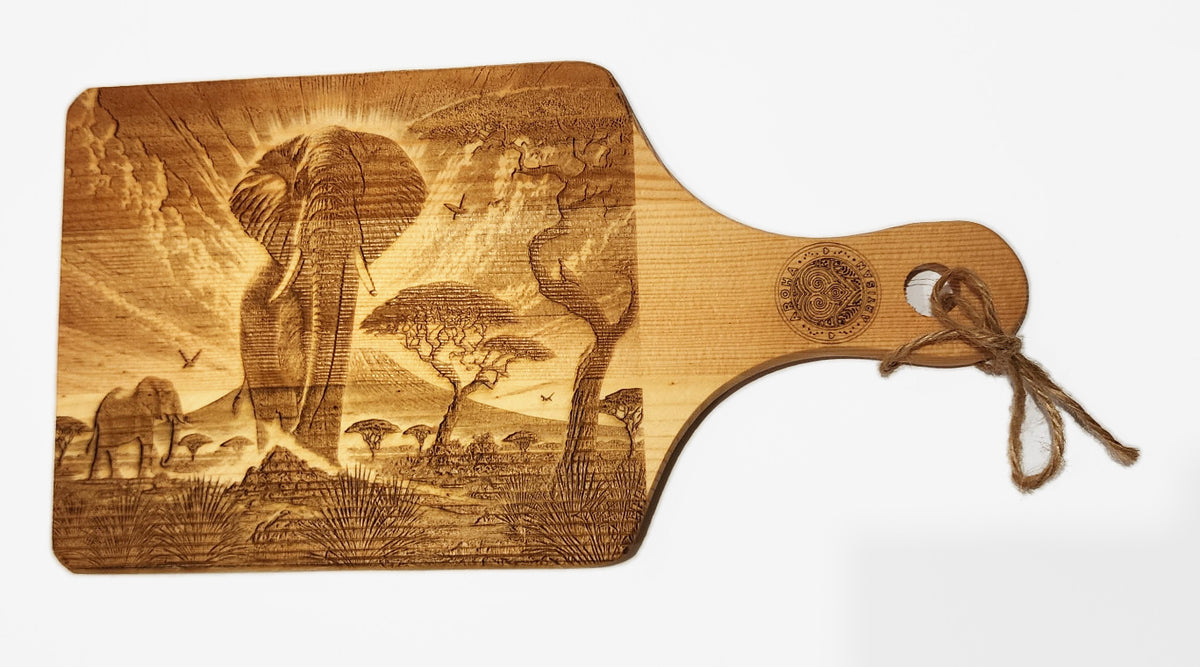 Elephant design on an Aroha Artisan mini engraved wooden board, showing elephants and acacia trees, with a handle.