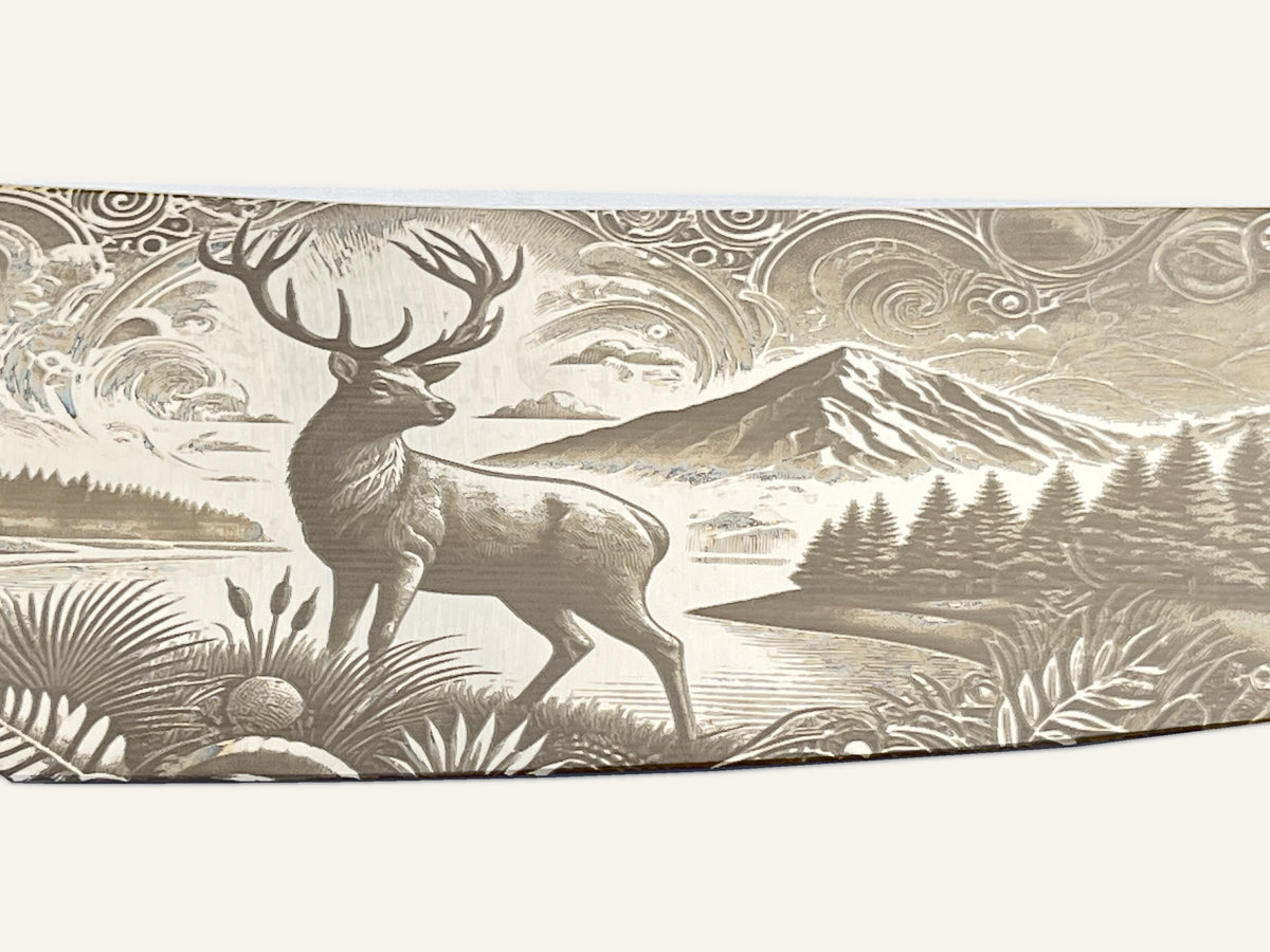 Detail of the stag, mountains and foliage engraved on the Spirit of the Outdoors cleaver