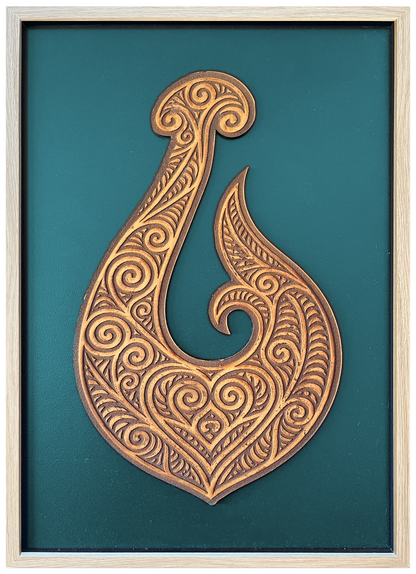 Manaia engraved cutout artwork with teal background and Ashwood frame — frame-finish composite and colour visualisation, not a new photograph.