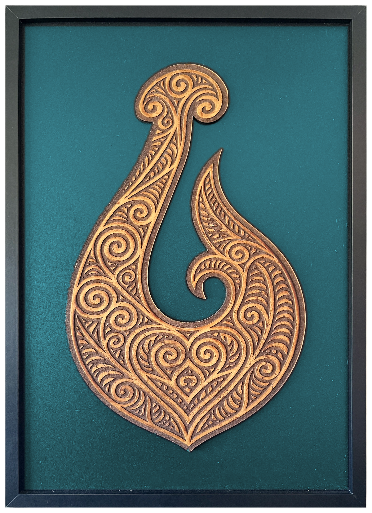 Manaia engraved cutout artwork with teal background and Black frame — colour visualisation, not a new photograph.