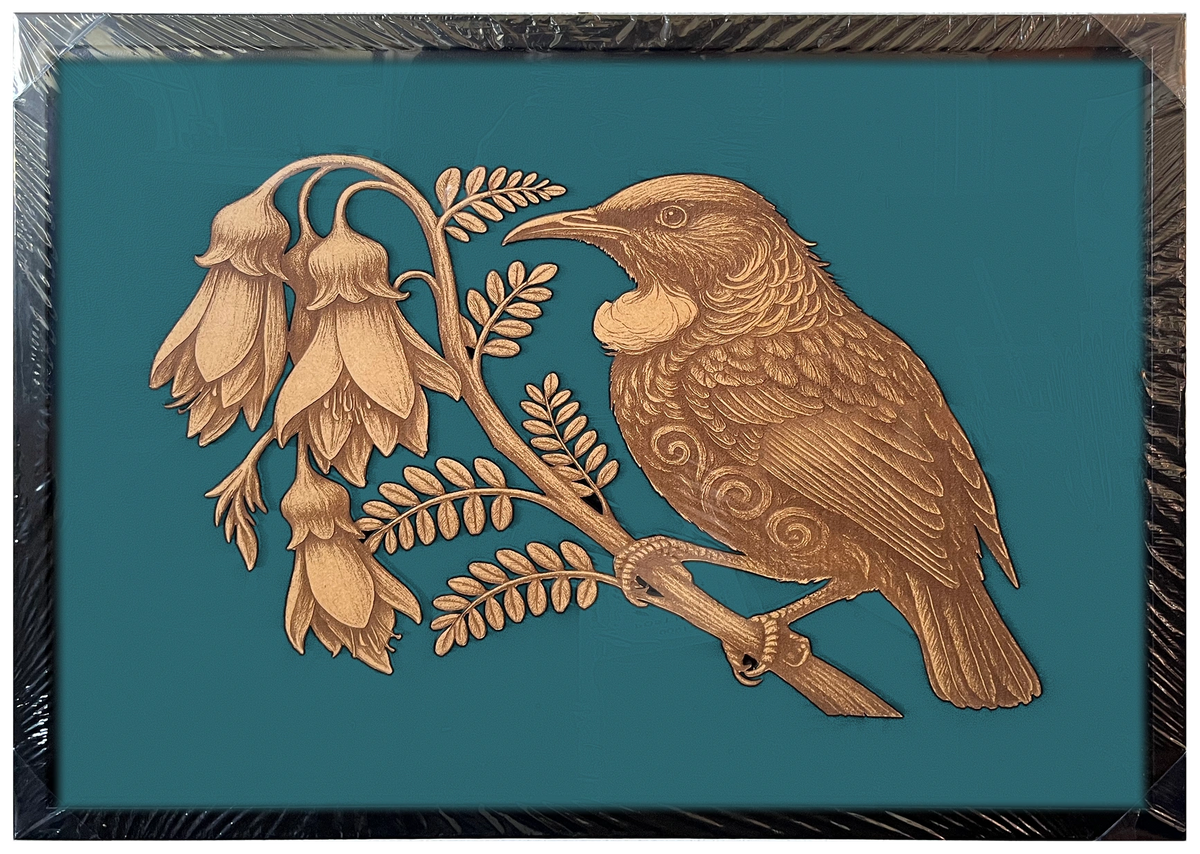Tūī in Kōwhai Tree engraved cutout artwork in an A2-size black frame with a deep teal background — colour visualisation