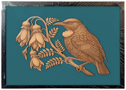 Tūī in Kōwhai Tree engraved cutout artwork in an A2-size black frame with a deep teal background — colour visualisation