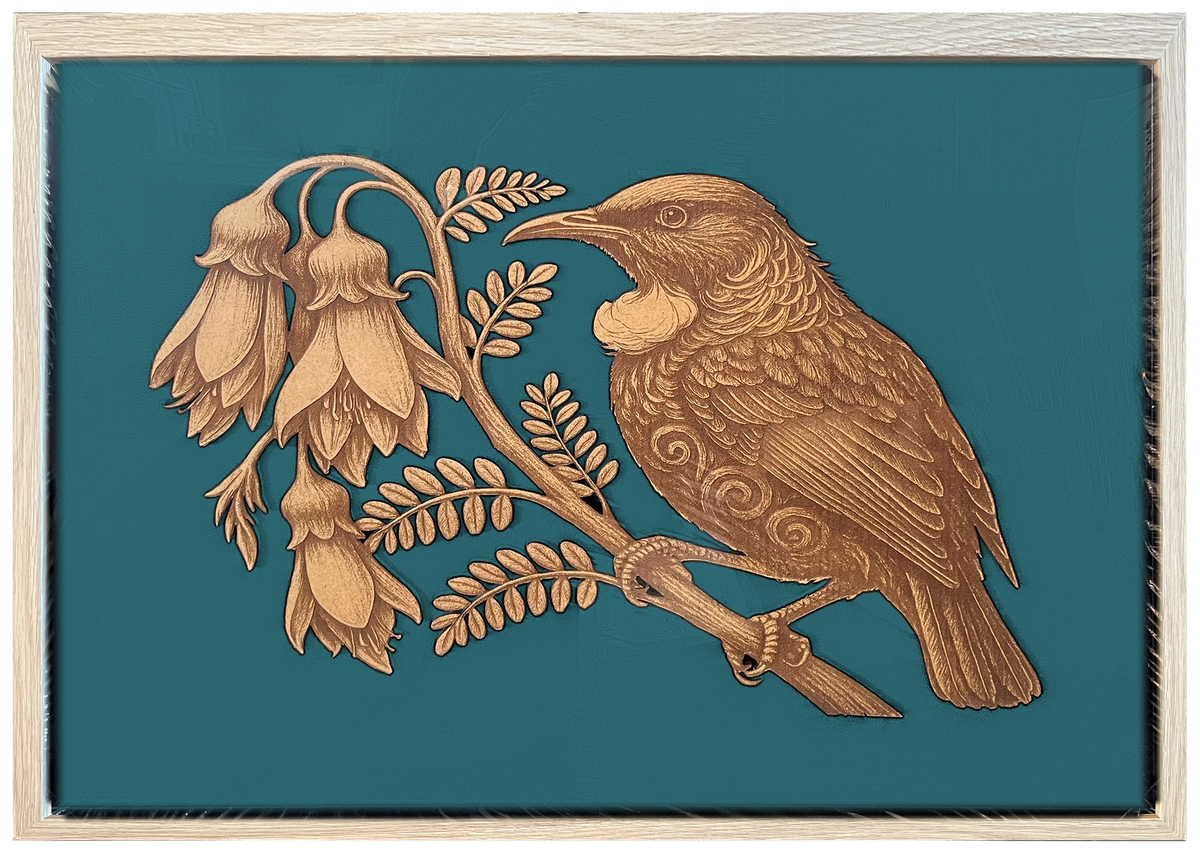 Tūī and Kōwhai engraved cutout artwork with teal background and Ashwood frame — frame-finish composite and colour visualisation, not a new photograph.